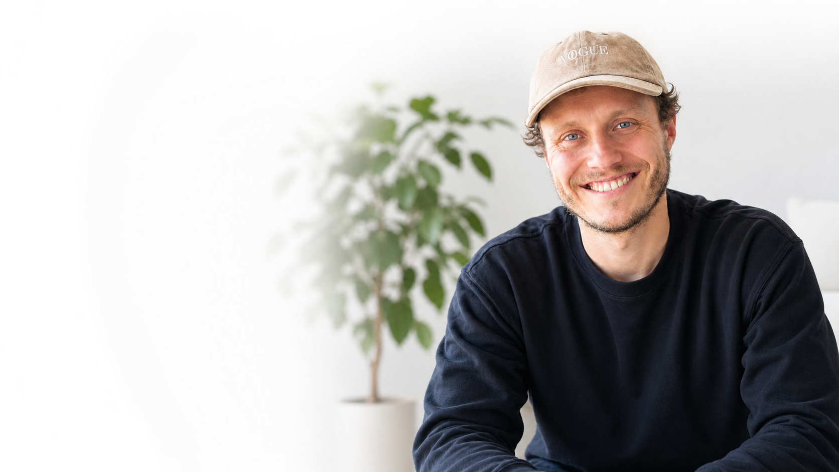 Lukas Bartels mit beiger Vogue-Kappe und schwarzem Pullover
